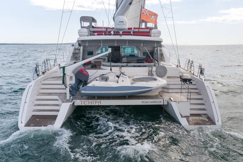 Tehiya Yacht Photos Pics Luxury Privilege 615 yacht from 2009 sailing with dinghy on open sea.