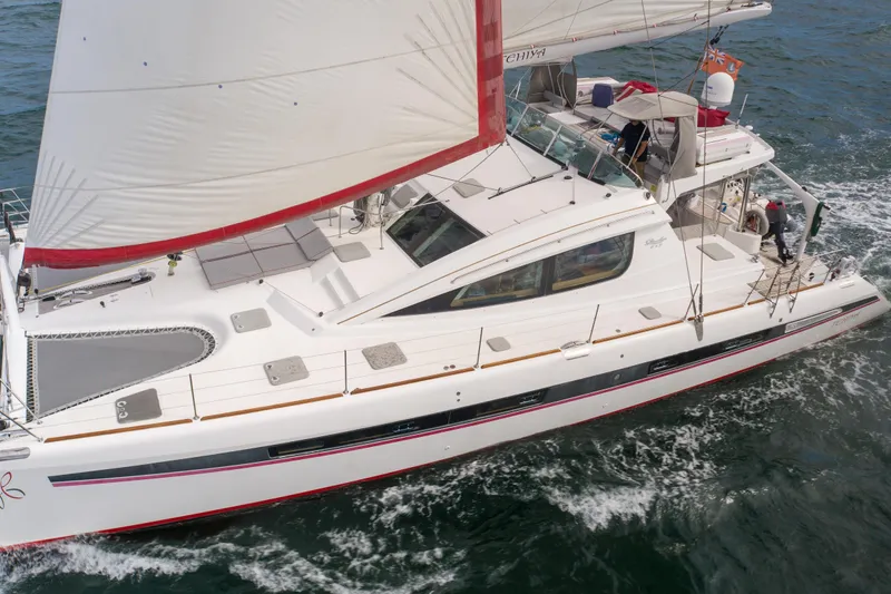 Tehiya Yacht Photos Pics Luxury Privilege 615 catamaran sailing on open water, 2009 model, white with red accents.