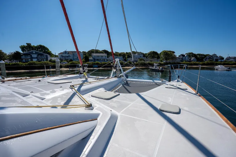 Tehiya Yacht Photos Pics Sailing yacht Privilege 615, 2009 model, docked near waterfront homes under clear blue sky.