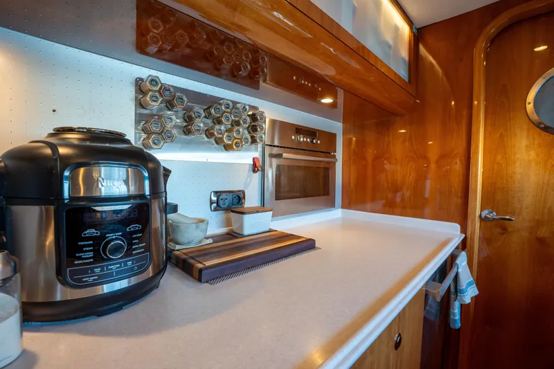 Tehiya Yacht Photos Pics Luxury yacht kitchen with modern appliances, wooden cabinetry, and sleek countertop. Privilege 615, 2009 model.