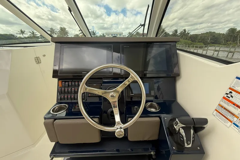 Yacht Photos Pics 2019 Pursuit DC 365 Dual Console helm with steering wheel, dual screens, and control panel.
