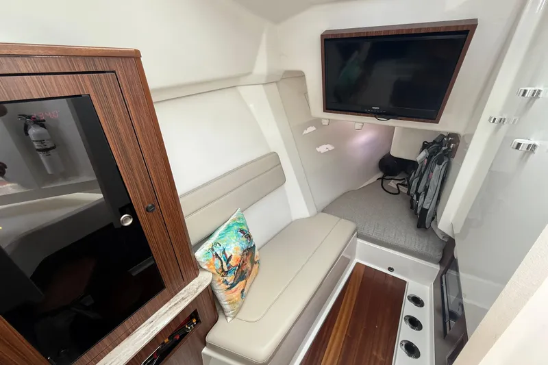  Yacht Photos Pics 2019 Pursuit DC 365 Dual Console cabin interior with seating, TV, and storage.