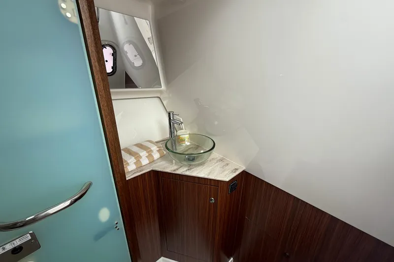  Yacht Photos Pics 2019 Pursuit DC 365 Dual Console bathroom with modern sink and wooden cabinetry.