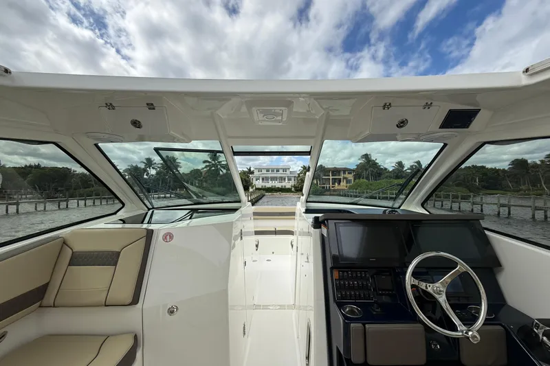  Yacht Photos Pics 2019 Pursuit DC 365 Dual Console boat interior with steering wheel and navigation screens.