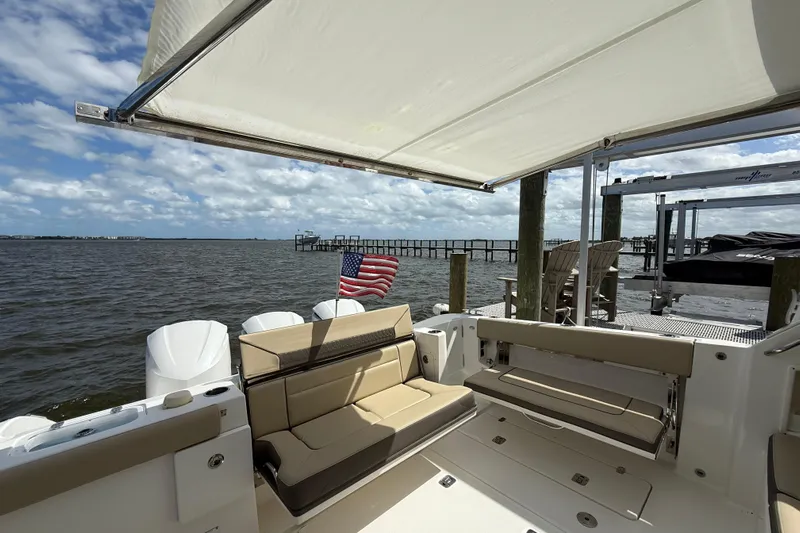  Yacht Photos Pics 2019 Pursuit DC 365 Dual Console boat with seating, docked by a pier under a blue sky.