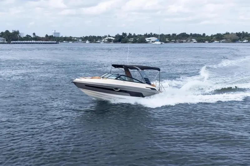  Yacht Photos Pics 2025 Hanover 255 boat cruising on a scenic waterway under a cloudy sky.