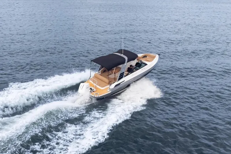  Yacht Photos Pics 2025 Hanover 255 boat cruising on open water, featuring sleek design and black canopy.