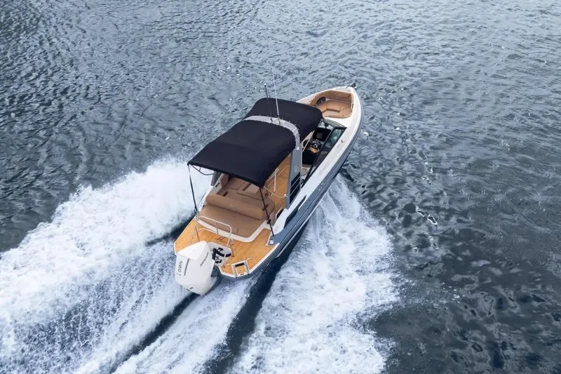  Yacht Photos Pics 2025 Hanover 255 boat cruising on open water with a black canopy.