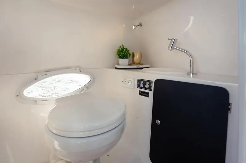 Yacht Photos Pics Modern bathroom in 2025 Hanover 255 boat with toilet, sink, and porthole.