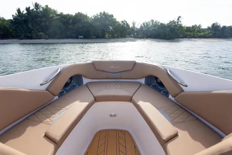  Yacht Photos Pics Luxurious interior of 2025 Hanover 255 boat with tan seating, near tropical shoreline.