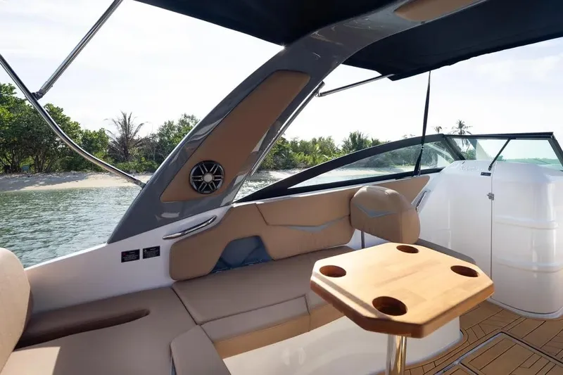  Yacht Photos Pics Luxurious interior of 2025 Hanover 255 boat with seating and table, near tropical shoreline.