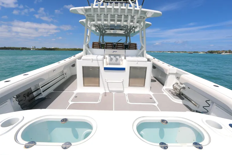 Alegria Yacht Photos Pics 2021 Yellowfin 54 Offshore boat on clear blue water, showcasing spacious deck and seating.