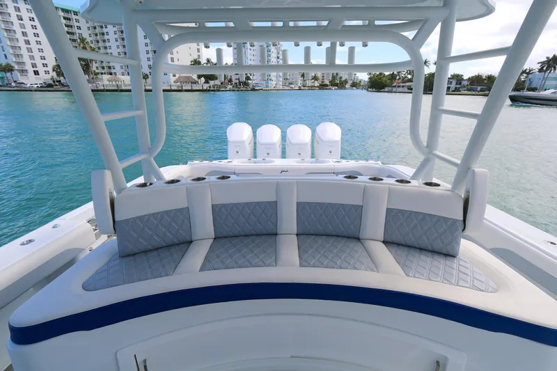 Alegria Yacht Photos Pics 2021 Yellowfin 54 Offshore boat with cushioned seating, overlooking a marina.