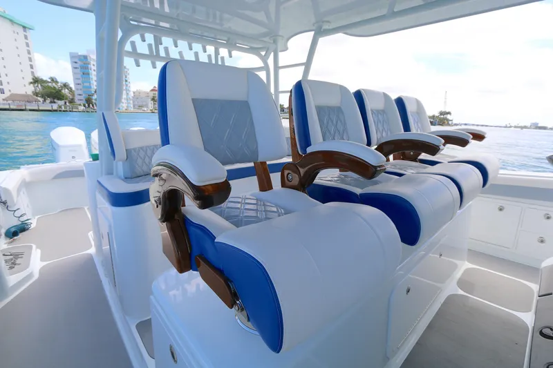 Alegria Yacht Photos Pics Luxurious seating on 2021 Yellowfin 54 Offshore boat, featuring blue and white cushioned chairs.