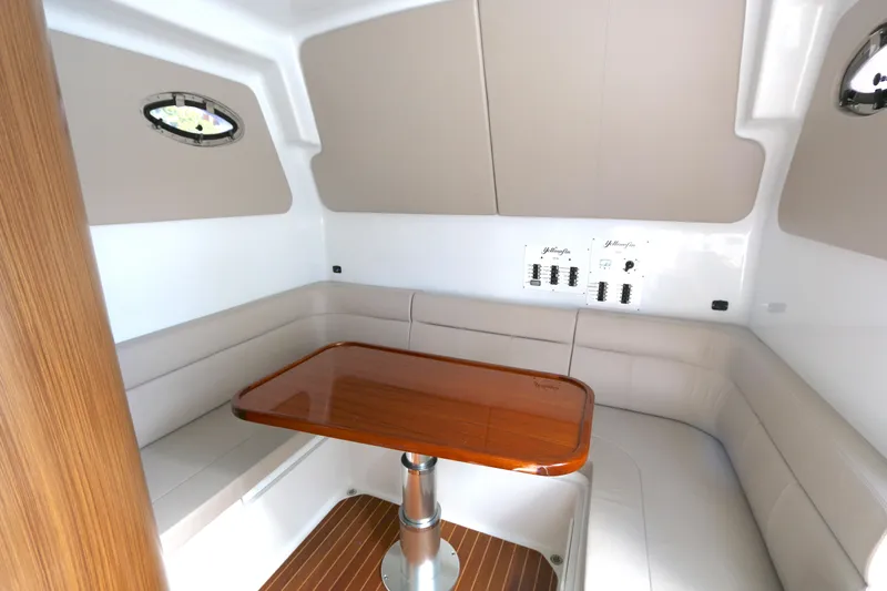 Alegria Yacht Photos Pics 2021 Yellowfin 54 Offshore cabin with elegant seating and wooden table.