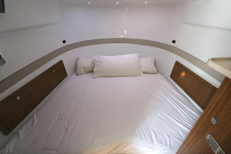Alegria Yacht Photos Pics 2021 Yellowfin 54 Offshore cabin with a cozy bed and wooden accents.