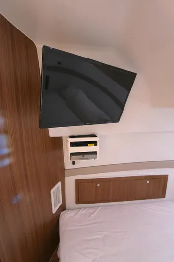 Alegria Yacht Photos Pics 2021 Yellowfin 54 Offshore cabin with mounted TV and wooden paneling.