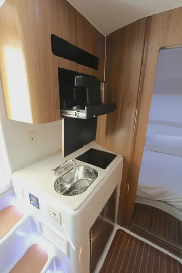 Alegria Yacht Photos Pics 2021 Yellowfin 54 Offshore interior with compact kitchenette and modern wood finish.