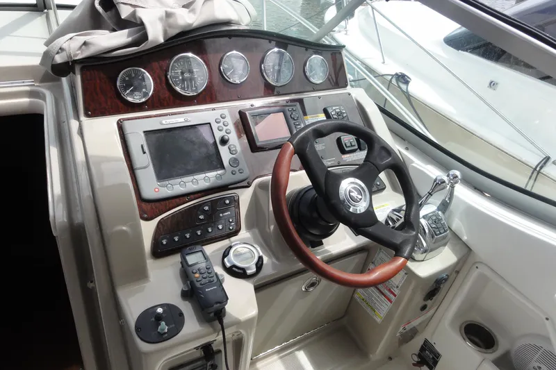 Sar Erinity Yacht Photos Pics Control panel of a 2009 Sea Ray 310 Sundancer boat with steering wheel and navigation instruments.