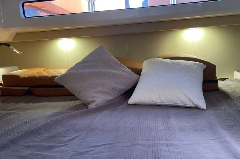 Nabu Yacht Photos Pics Cozy cabin interior of 2023 SACS Strider 15 with pillows and ambient lighting.