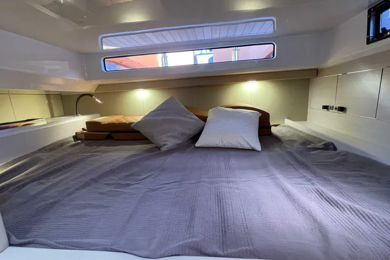 Nabu Yacht Photos Pics Cozy cabin interior of 2023 SACS Strider 15 with comfortable bedding and ambient lighting.
