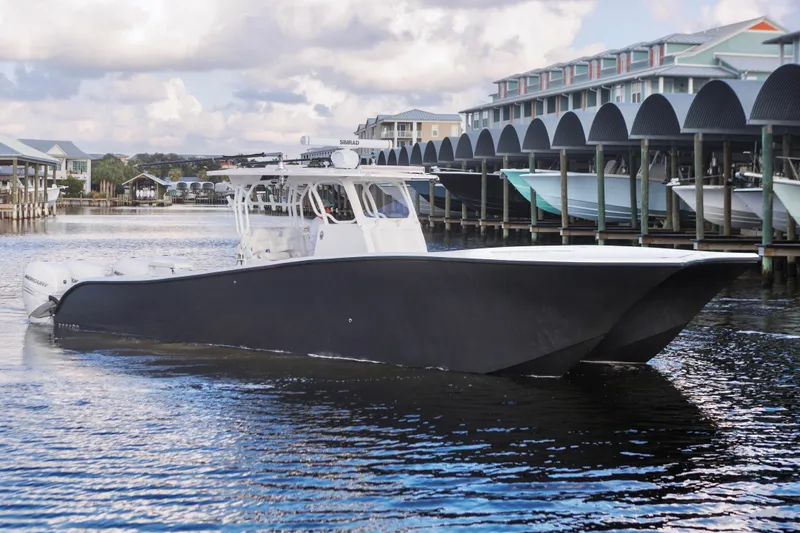  Yacht Photos Pics 2021 Tag 360 Catamaran cruising in marina with modern architecture in background.