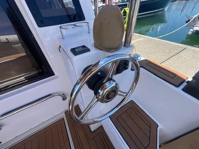 Red Diver Yacht Photos Pics 2022 Ranger Tugs R-29 S helm with polished steering wheel and wood accents.