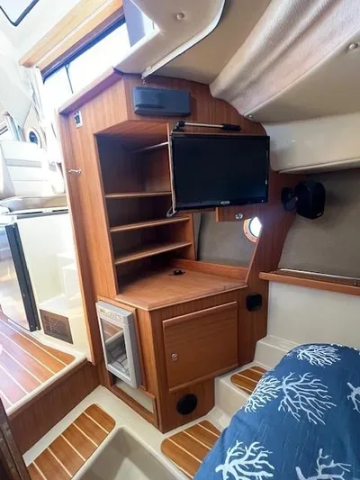 Red Diver Yacht Photos Pics 2022 Ranger Tugs R-29 S interior with wood cabinetry and mounted TV.