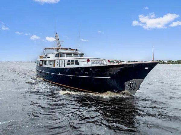 Chanticleer Yacht Photos Pics Classic 1973 Burger 310C yacht cruising on open water under a clear blue sky.
