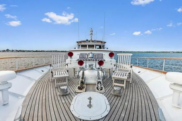 Chanticleer Yacht Photos Pics Deck view of 1973 Burger 310C yacht with wooden flooring and seating, under a clear blue sky.