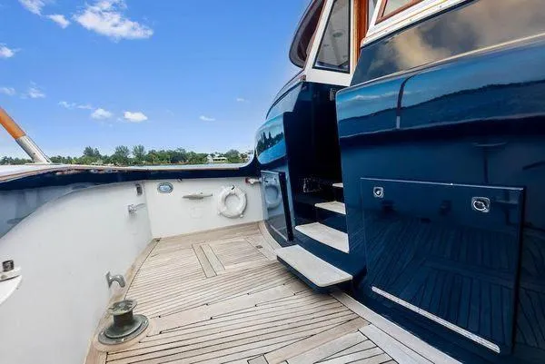 Chanticleer Yacht Photos Pics 1973 Burger 310C yacht deck with wooden flooring and blue exterior under clear sky.