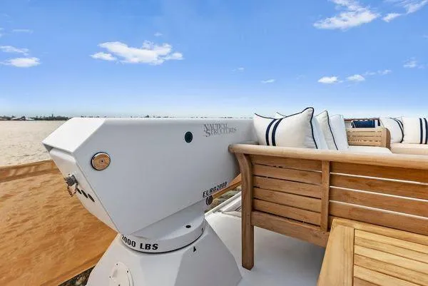 Chanticleer Yacht Photos Pics 1973 Burger 310C yacht deck with wooden seating and cushions under a clear blue sky.