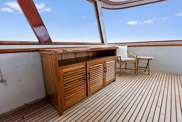 Chanticleer Yacht Photos Pics Wooden deck with cabinet and chair on a 1973 Burger 310C yacht.