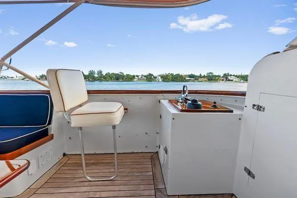 Chanticleer Yacht Photos Pics 1973 Burger 310C yacht helm with seating, overlooking serene water and blue sky.