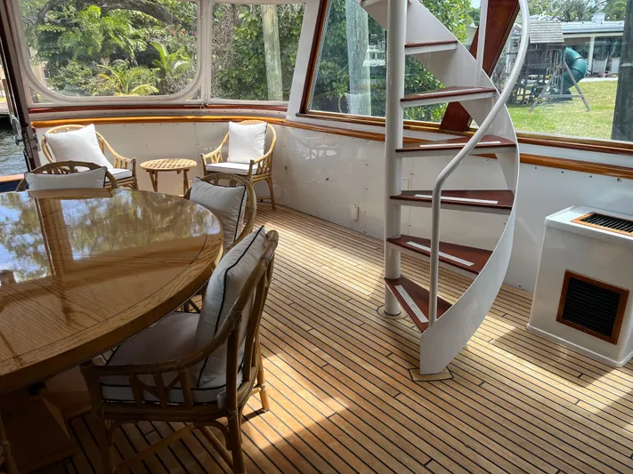 Chanticleer Yacht Photos Pics Luxurious yacht interior with spiral staircase, wooden flooring, and elegant seating, model Burger 310C, 1973.