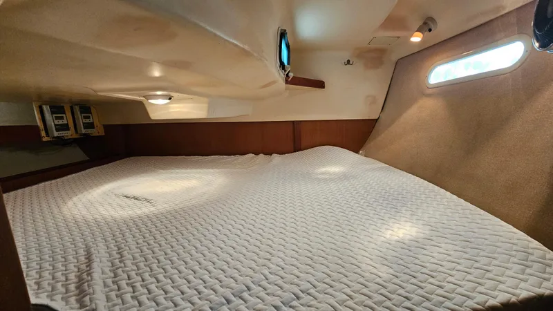  Yacht Photos Pics Interior cabin of 1998 Hunter 340 Sloop with cozy bedding and porthole windows.