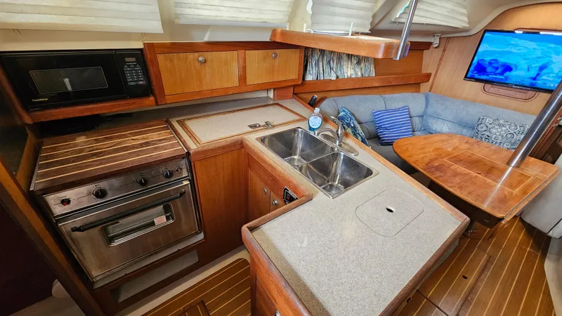  Yacht Photos Pics Interior of 1998 Hunter 340 Sloop with kitchen, sink, and seating area.