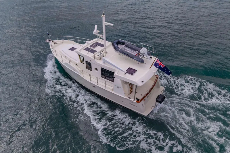 Nordhavn 41 Yacht Photos Pics 2023 Nordhavn 41 yacht cruising on open water, featuring Australian flag.