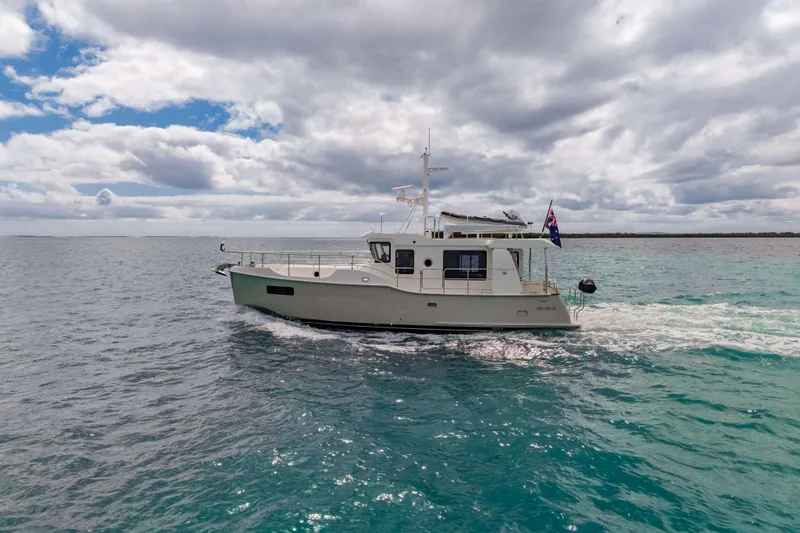 Nordhavn 41 Yacht Photos Pics 2023 Nordhavn 41 yacht cruising on open sea under cloudy sky.