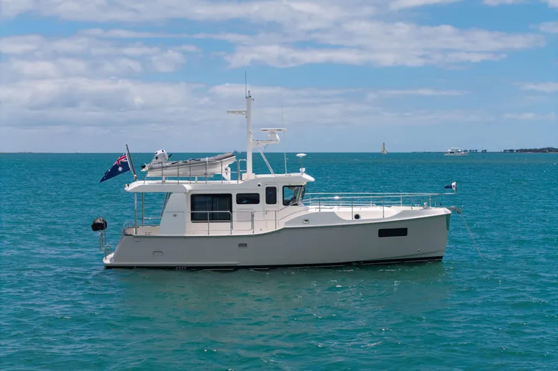 Nordhavn 41 Yacht Photos Pics 2023 Nordhavn 41 yacht on calm blue ocean under a partly cloudy sky.
