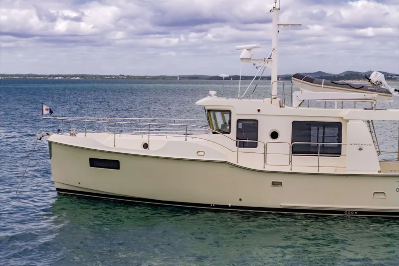Nordhavn 41 Yacht Photos Pics 2023 Nordhavn 41 yacht on calm sea with cloudy sky backdrop.