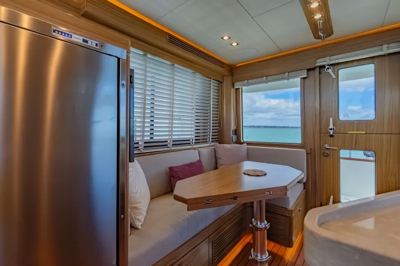 Nordhavn 41 Yacht Photos Pics 2023 Nordhavn 41 yacht interior with dining area, wooden accents, and ocean view.