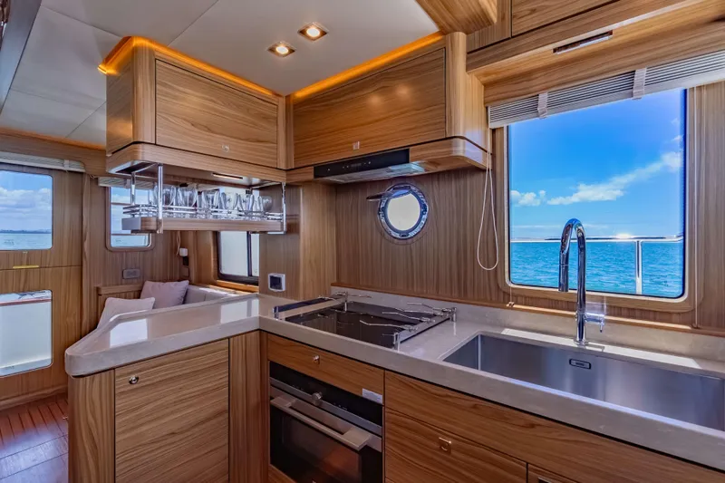 Nordhavn 41 Yacht Photos Pics Luxurious 2023 Nordhavn 41 yacht kitchen with ocean view, modern wood cabinetry, and sleek appliances.