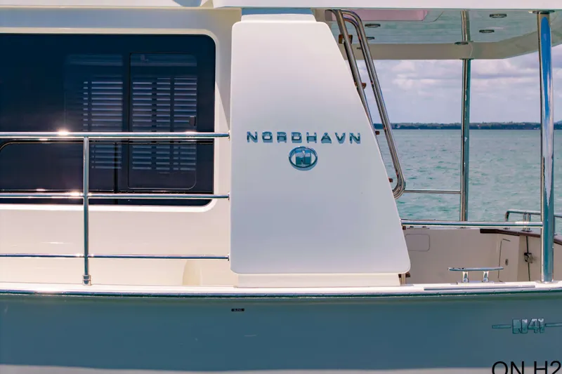Nordhavn 41 Yacht Photos Pics 2023 Nordhavn 41 yacht exterior with logo, docked by the sea.