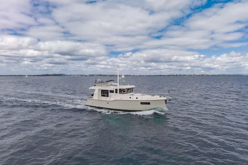 Nordhavn 41 Yacht Photos Pics 2023 Nordhavn 41 yacht cruising on open water under a partly cloudy sky.