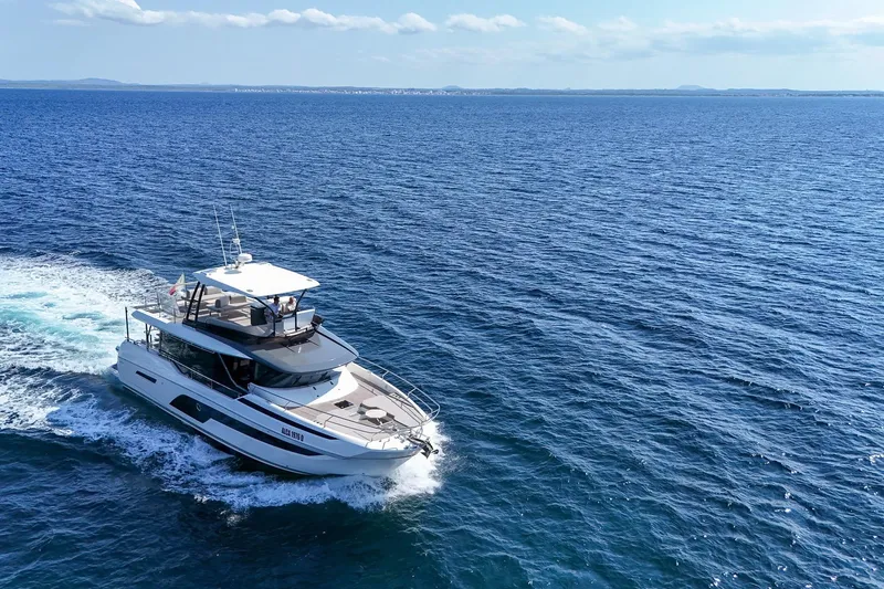  Yacht Photos Pics 2023 Prestige X60 yacht cruising on open blue sea under clear sky.