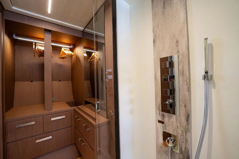  Yacht Photos Pics Luxurious 2023 Prestige X60 yacht interior with elegant wooden closet and modern shower controls.
