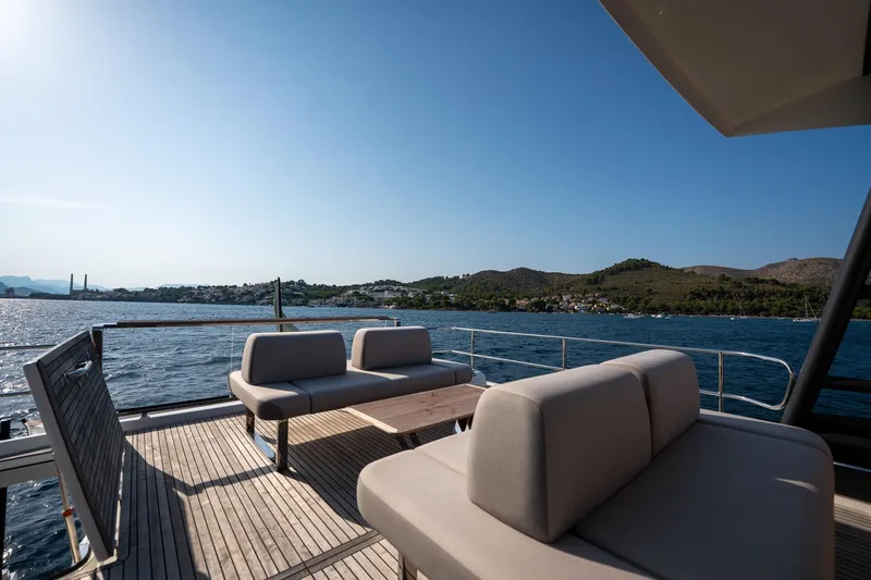  Yacht Photos Pics Luxurious 2023 Prestige X60 yacht deck with elegant seating, overlooking serene coastal waters.
