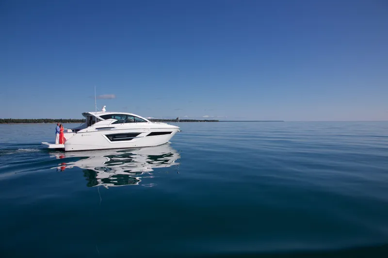  Yacht Photos Pics 2026 Cruisers Yachts 46 Cantius on calm water under clear blue sky.