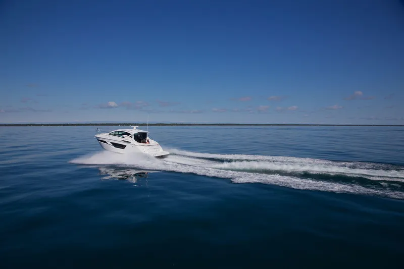  Yacht Photos Pics 2026 Cruisers Yachts 46 Cantius cruising on calm blue waters under clear skies.